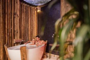 a man and woman sitting in a bath tub at Mirabell Dolomites Hotel - Luxury Ayurveda & Spa in Valdaora +88 photos