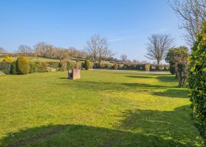 a grassy field with trees and bushes in a park at Bucklegrove Holiday Resort in Rodney Stoke