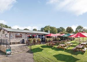 a restaurant with tables and umbrellas on the grass at Bucklegrove Holiday Resort in Rodney Stoke