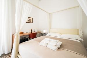 una camera da letto bianca con due letti e una scrivania di Catammari a Catania