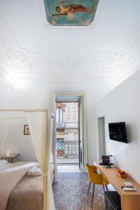 una camera da letto con un letto, una scrivania e una finestra di Catammari a Catania