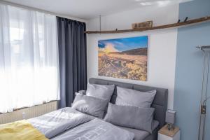 a bedroom with a bed and a large window at Treibholz in Norderney