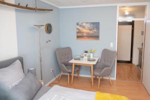 a room with a table and chairs and a bed at Treibholz in Norderney