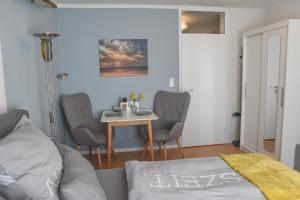 a living room with a table and chairs and a bed at Treibholz in Norderney +8 photos