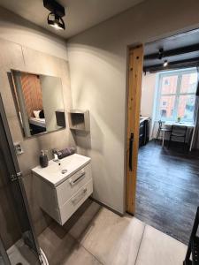 un baño con lavabo y espejo en Apartament z widokiem na pomnik Kopernika - Rynek Staromiejski, en Toruń
