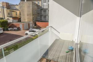a balcony with a table and chairs and a view of a parking lot at Treibholz in Norderney