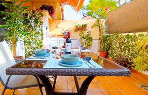 stół z dwoma daniami i butelką wina w obiekcie Apartamento Las 3P Piscina, Paz y Patio privado w mieście Fuengirola