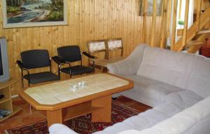 a living room with a couch and a table and chairs at Amazing Home In Ljungby With Wifi in Bolmstad