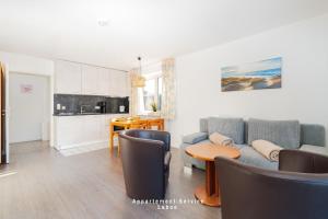 a living room with a couch and a table at Bellevue W07 in Laboe +8 photos