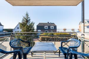 a patio with chairs and a table on a balcony at Bellevue W07 in Laboe