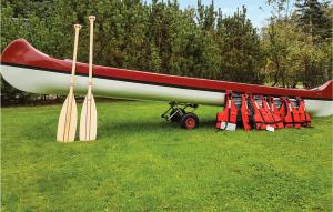 ein Boot auf einem Feld mit Paddeln in der Unterkunft Holiday Home Ålbækparken Spøttrup Ii in Ålbæk