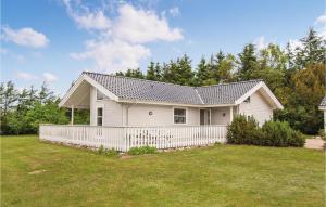 ein weißes Haus mit einem Zaun im Hof in der Unterkunft Holiday Home Ålbækparken Spøttrup Ii in Ålbæk