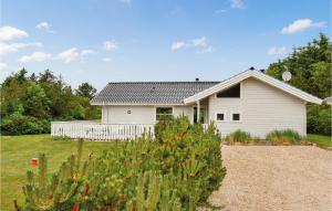 ein weißes Haus mit einem Zaun im Hof in der Unterkunft Holiday Home Ålbækparken Spøttrup Ii in Ålbæk