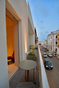 a table on a balcony with a view of a street at MpiuT Exclusive Rooms - Housea in Polignano a Mare +16 photos