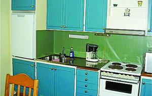 a kitchen with blue cabinets and a stove and a sink at Pet Friendly Home In Ljungby With Wifi in Bolmstad
