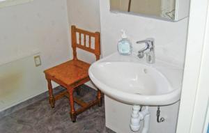 a bathroom with a sink and a chair at Pet Friendly Home In Ljungby With Wifi in Bolmstad +3 photos