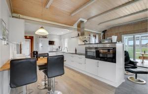 a kitchen with white cabinets and a wooden ceiling at Amazing Home In Thisted With Sauna in Sønder Vorupør