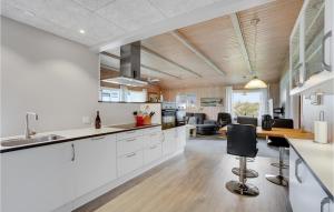 a kitchen with white cabinets and a living room at Amazing Home In Thisted With Sauna in Sønder Vorupør