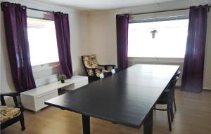 a dining room with a table and two windows at Amazing Home In Ljungby With Lake View in Bolmstad