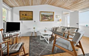 a living room with a couch and a tv at Holiday Home Bølsbakke Svaneke V in Svaneke
