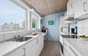 a kitchen with a sink and a window at Holiday Home Bølsbakke Svaneke V in Svaneke