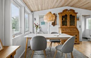 a dining room with a table and chairs at Holiday Home Bølsbakke Svaneke V in Svaneke