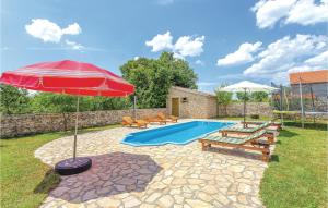 a pool with a red umbrella and chairs and a table at Cozy Home In Sibenik With Sauna in Puljane