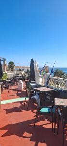 a row of tables and chairs on a patio with the ocean at Marazul By Fitzgeralds in Nerja
