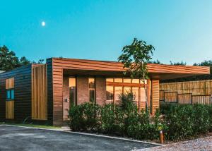 a house with a wooden facade with a driveway at Goosedale Lodges in Nottingham