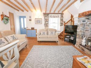 a living room with a couch and a tv at Bramley Cottage in Beaumaris +25 photos