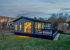 a small black tiny house on a grass field at Rivendale Lodge Retreat in Ashbourne +41 photos
