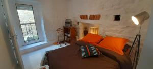 a bedroom with a bed with orange pillows and a window at Appartement quartier des Halles in Douarnenez