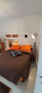 ドゥアルヌネにあるAppartement quartier des Hallesのオレンジ色の枕が付いた大きなベッドのある寝室