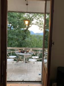szklanymi drzwiami prowadzącymi na patio ze stołem i krzesłami w obiekcie Ô mon beau refuge T2 - 75m2 w Aix-les-Bains