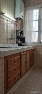 a kitchen with wooden cabinets and a sink and a window at El Hartoune S in Tlemcen