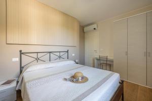 una camera da letto con un letto con un cappello sopra di Residenza Marano a Cupra Marittima Altre 28 foto