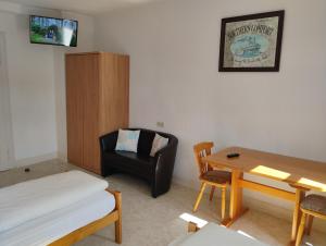 a room with a bed and a chair and a table at Hotel Kremer in Büchenbeuren