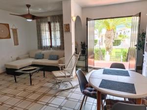 a living room with a couch and a table at Bungalow con vistas a la piscina in Torrevieja