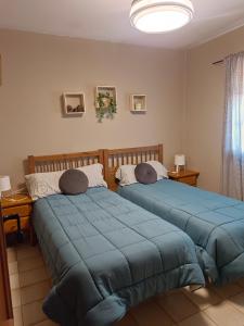 twee bedden in een kamer met blauwe lakens bij Bungalow con vistas a la piscina in Torrevieja