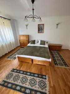 a bedroom with a bed and two rugs at La Colonelu in Sărata-Monteoru