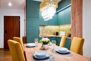 a dining room with a wooden table with chairs at Baltic Waves Resort by Baltic Home in Międzyzdroje
