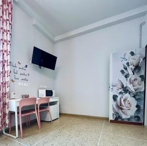 a dining room with a table and a tv on a wall at La Teranga in Imola