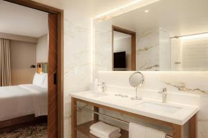 un bagno con lavandino, specchio e letto di Four Points by Sheraton Tequendama, Bogota a Bogotá