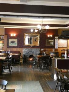 a restaurant with tables and chairs and a fireplace at Ythanview Hotel in Methlick +28 photos