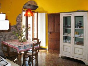 a dining room with a table and a yellow wall at Apartment Limone by Interhome in Dolcedo