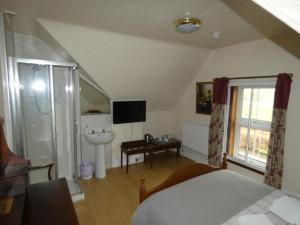 a bedroom with a bed and a sink and a bathroom at Ythanview Hotel in Methlick