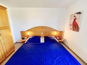 a bedroom with a bed with blue sheets on it at Apartment Schwarzwaldblick IV by Interhome in Bernau im Schwarzwald +50 photos