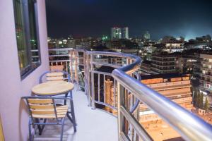 d'un balcon avec deux chaises et une table. dans l'établissement Hong Kong Hotel, à Dar es Salaam