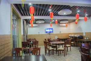 una sala da pranzo con tavoli, sedie e lanterne rosse di Hong Kong Hotel a Dar es Salaam Altre 37 foto