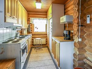 een keuken met houten kasten en een fornuis bij Holiday Home Illankajo by Interhome in Suninsalmi